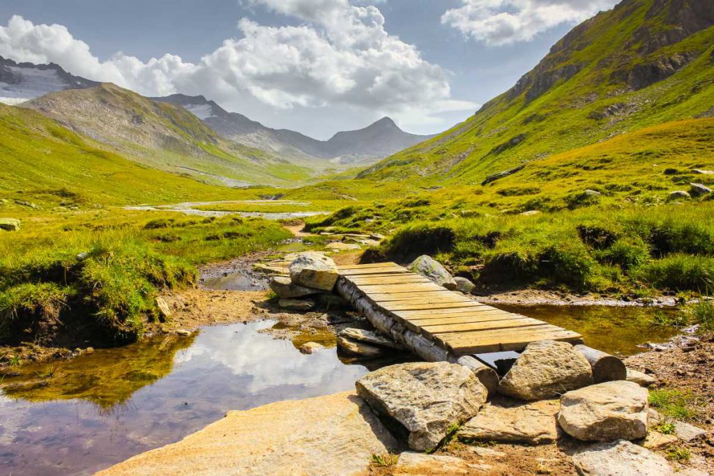 Holzige Brücke über seichtes Gewässer in den Schweizer Alpen