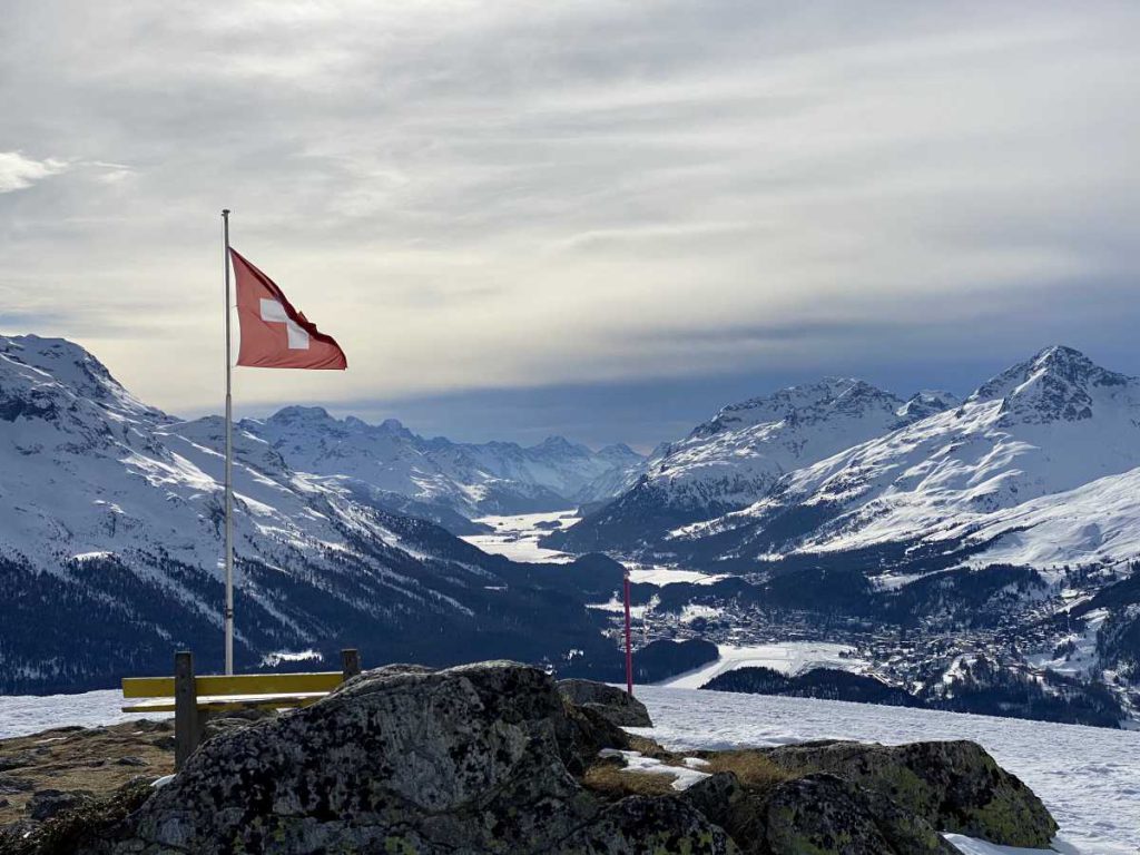 Immer eine schöne Belohnung, wenn der Weg sich gelohnt hat. Blick vom Muottas Muragl - einem Ausflugsberg mit einer Höhe von 2453 m ü. M mit Sitzbank und Schweizer Flagge