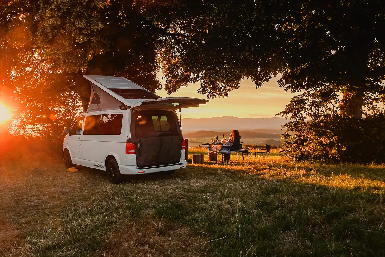 a camper van in nature under trees