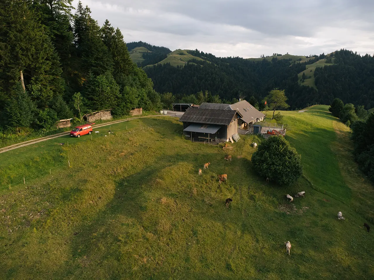 swiss meadows and mountains with a camper van in the middle