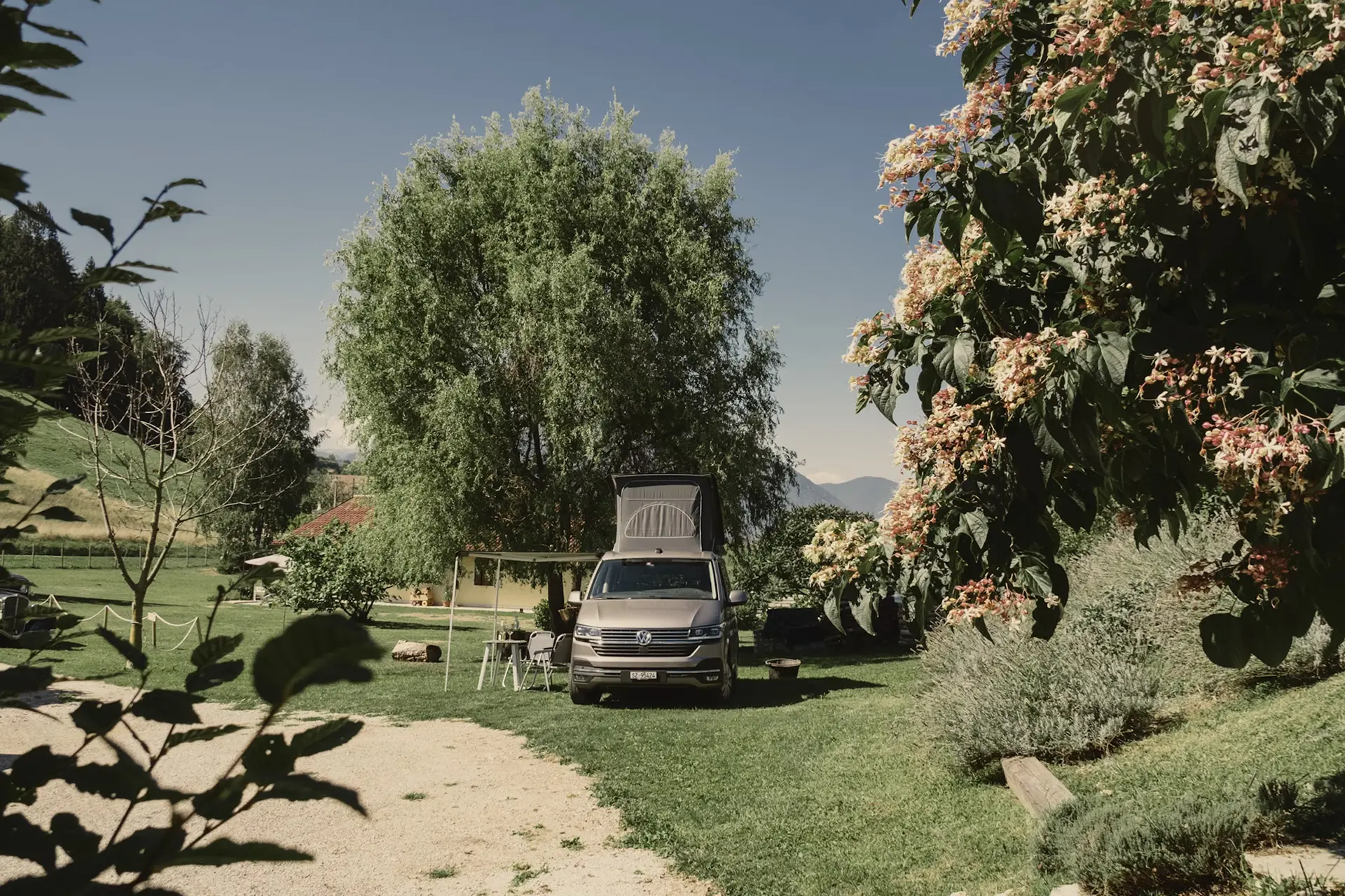 swiss meadows and mountains with a camper van in the middle