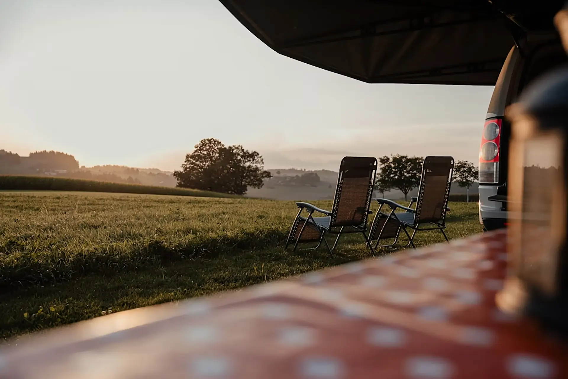 swiss meadows and mountains with a camper van in the middle