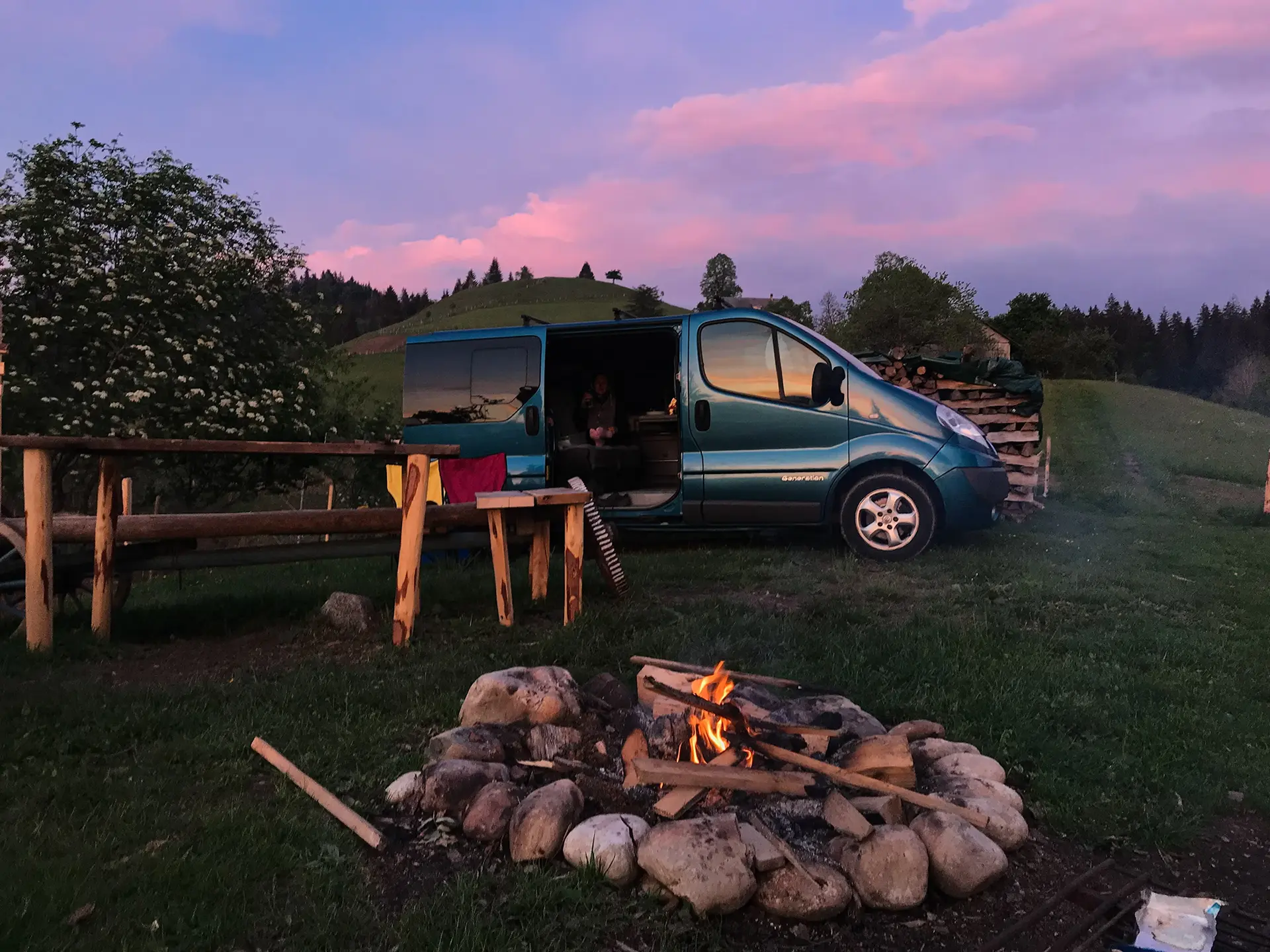 swiss meadows and mountains with a camper van in the middle