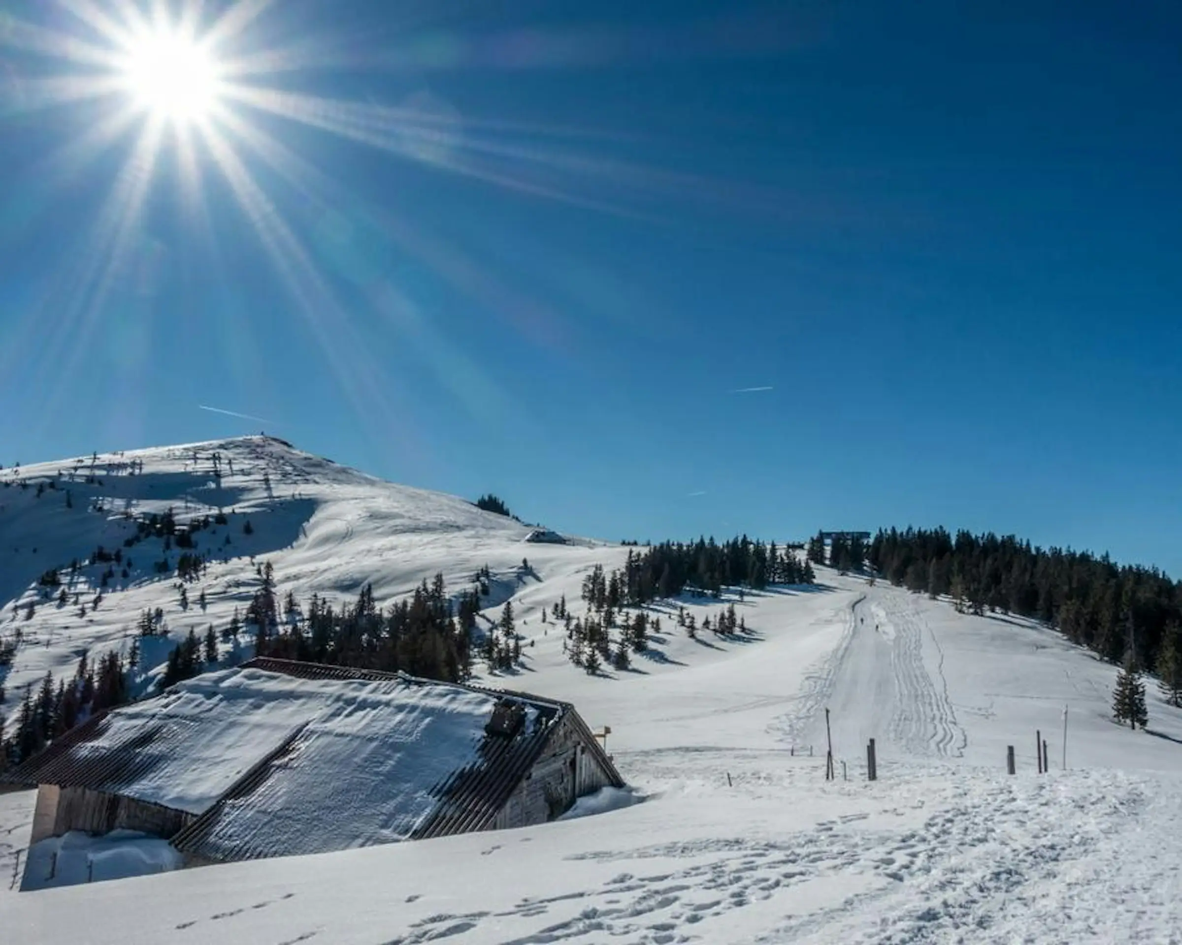 Winterlandschaft auf Alp Cousimbert mit verschneiten Hügeln und klassischen Alpweiden