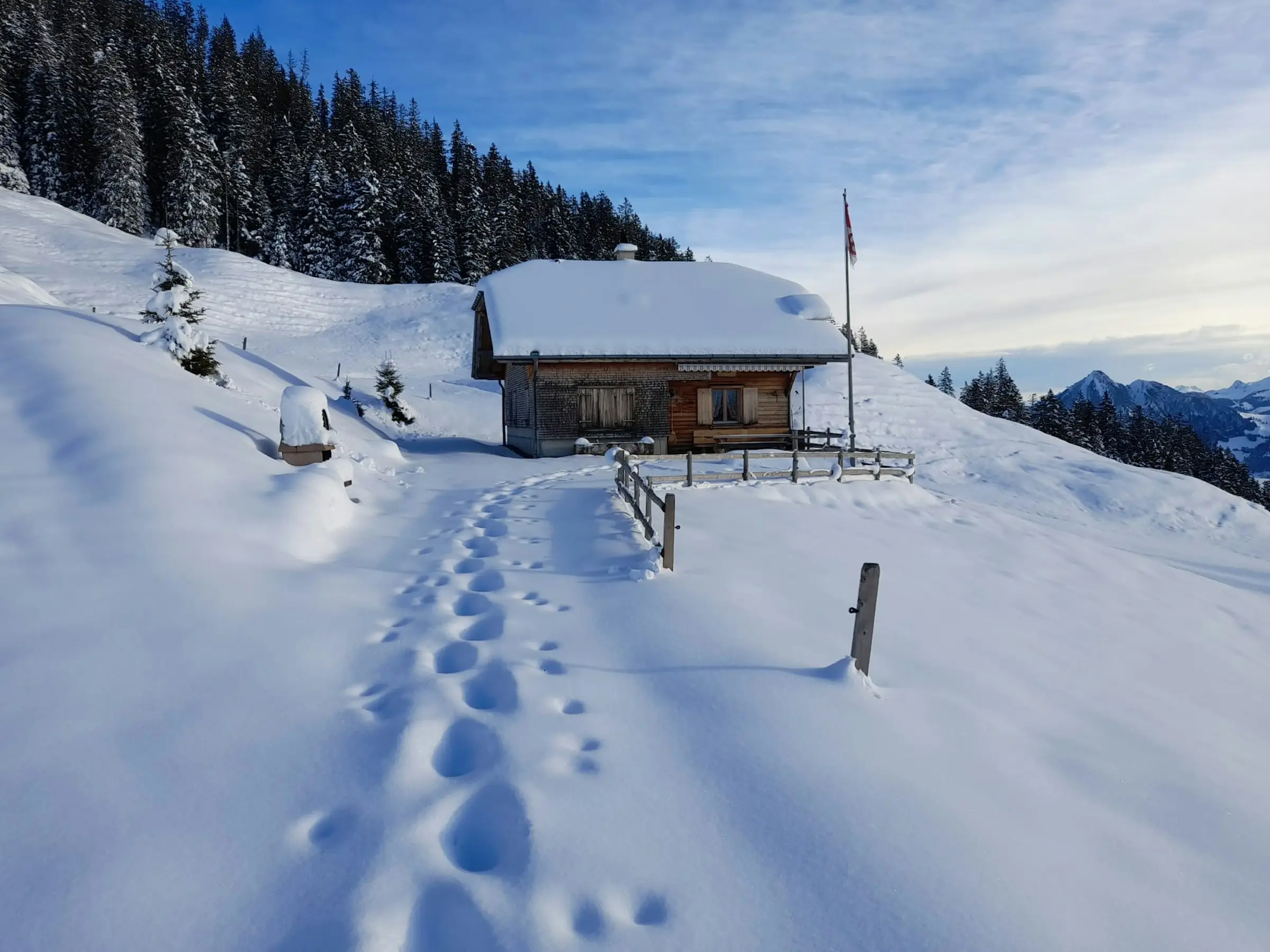 Nomady Alp Eisten im Winter mit verschneiten Alpwiesen und Hütten