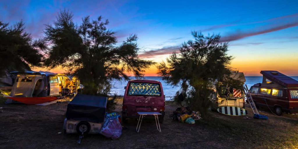 Vanlife mit maximaler Freiheit Mehrere Campingbusse campieren direkt am Meer.