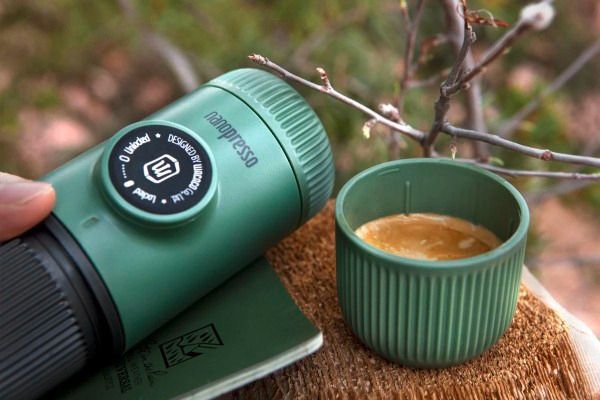 Wacaco Nanopresso in Grün mit frisch gebrühtem Espresso und Crema im Freien