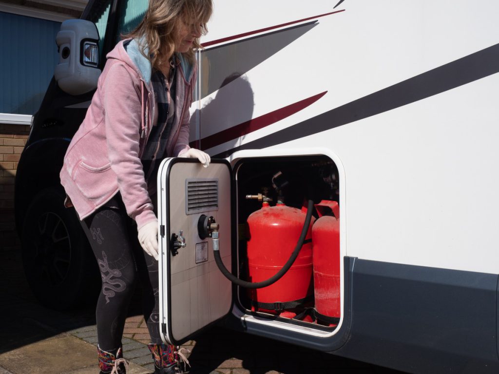 gas entleeren und abdrehen, Verbindung kappen und Kappe drauf Frau-begutachtet-Gasflaschen-vom-Wohnmobil